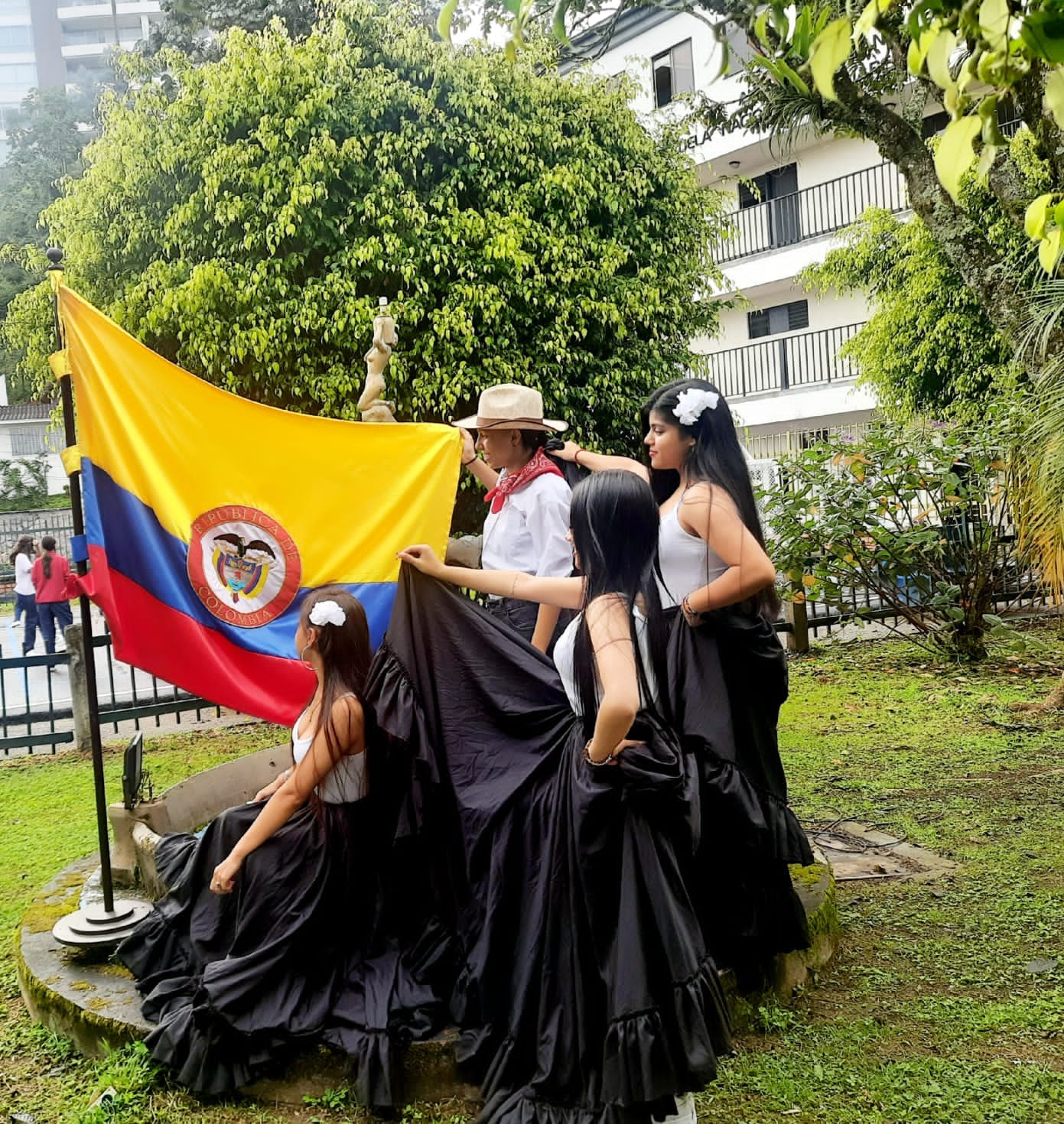 Bailarinas de undécimo grado posando con la bandera de Colombia