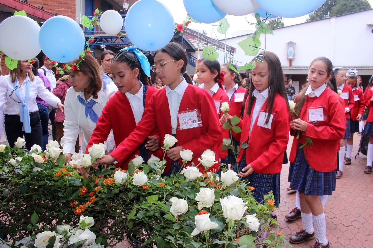 Estudiantes de primaria haciendo ofrecimiento floral